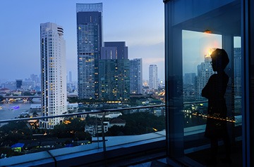 Business person looking out window over downtown scene