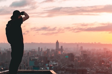photographer taking picture of city scape at sunset