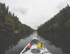 kayak in water flanked by woods