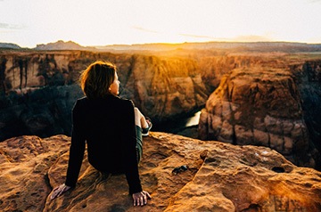 hiker watching sunset over hills